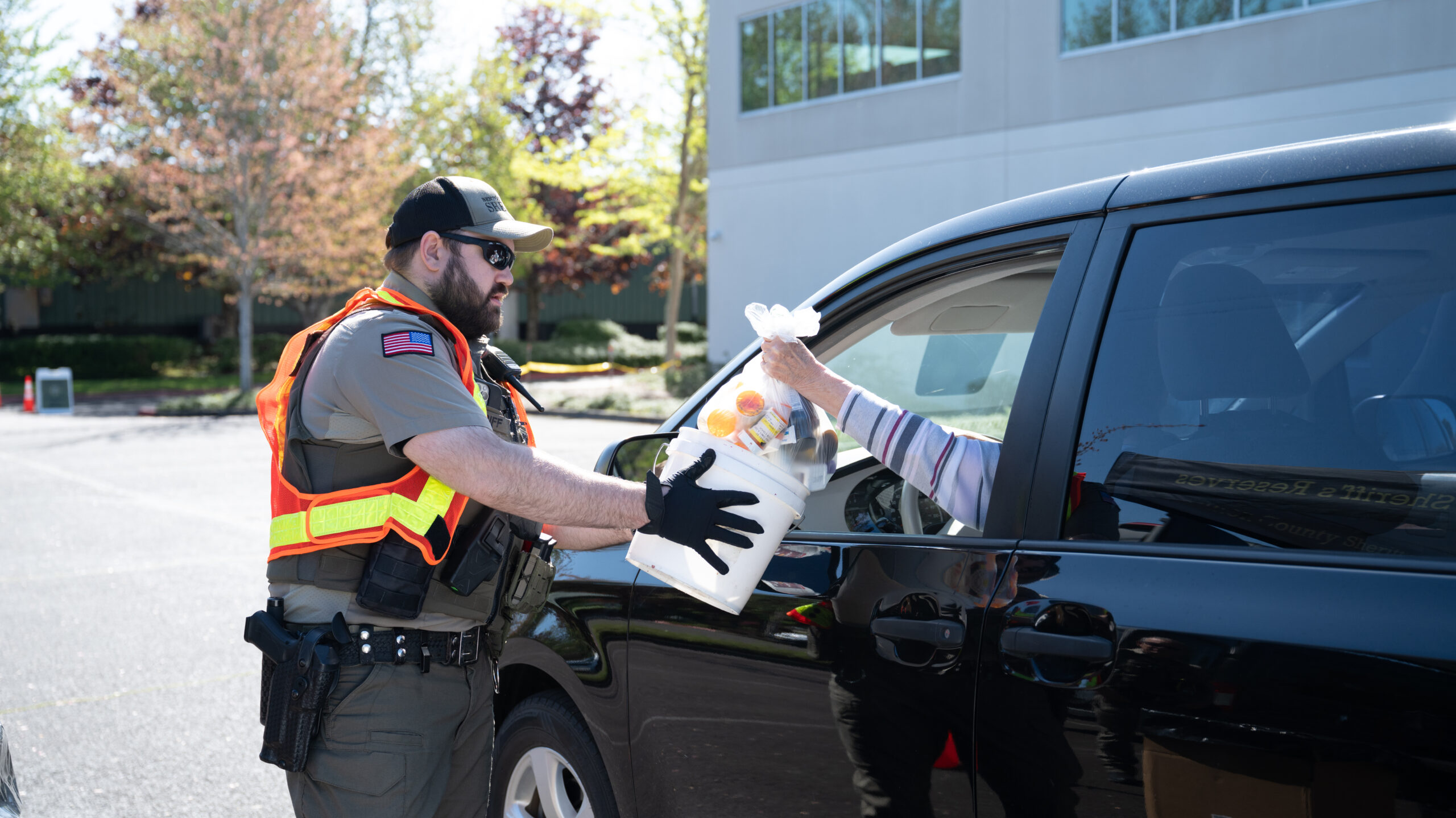 A Deputy collecting prescription and over the counter drugs at the Drug Take Back event from a person driving through.
